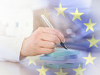 ръка с писалка и лого на ЕС